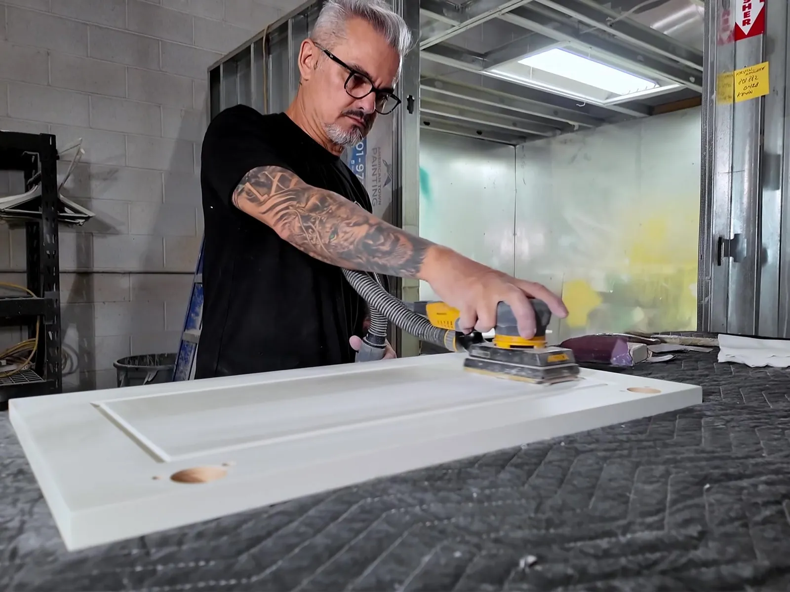 Sanding a cabinet door in the workshop — White Fox Cabinets